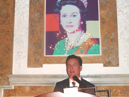 Bonhams&#039; Dr. Martin Gammon welcomes guests at British Embassy under Andy Warhol portrait of Queen Elizabeth