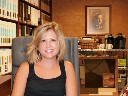 Karen Swarthout Ohri in front of a photo of her grandfather, Herbert Swarthout