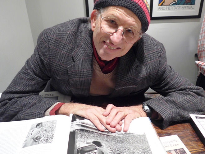 Peter Simon with his book opened to Bob Dylan photo
