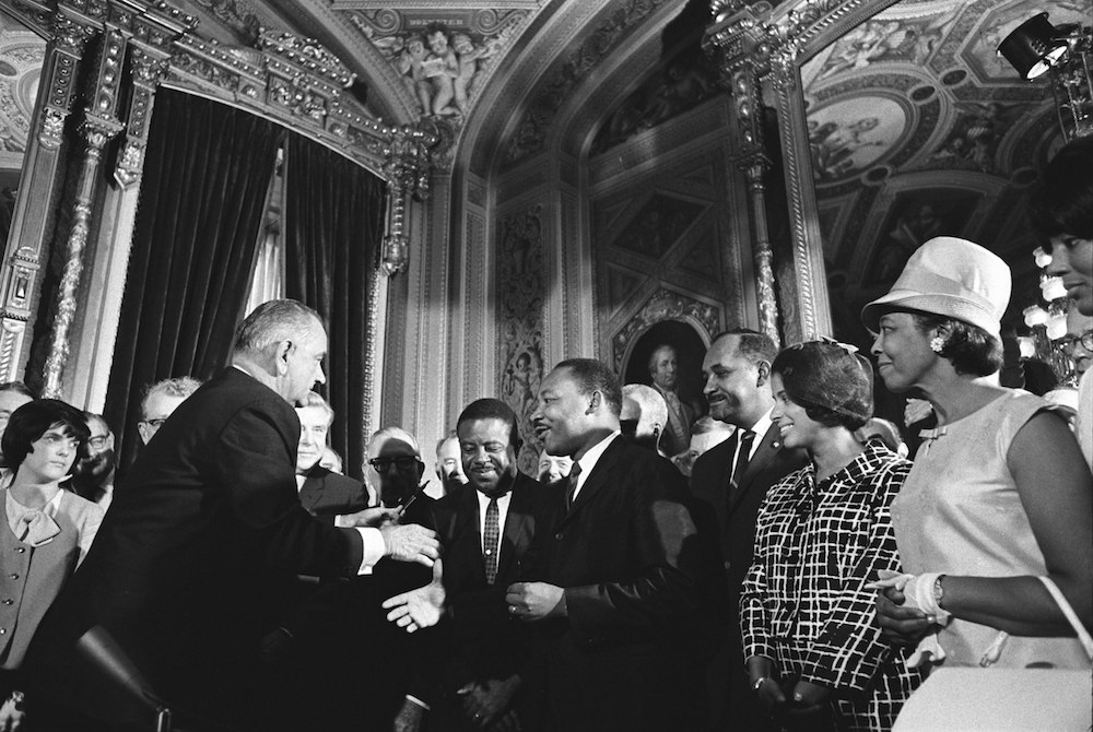 President Lyndon B. Johnson, Martin Luther King, Jr., and Clarence Mitchell Jr. at the signing of the Voting Rights Act
