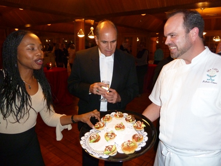 Chef Nate Coons serving Cumin Corn Blinis to Sylvie Luanghy and Zubair Popal