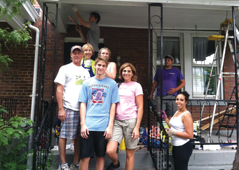 Volunteers gathered on the front porch of a Columbia Heights home, where they worked on various home improvement projects.