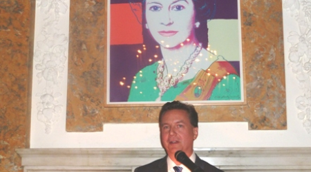 Bonhams&#039; Dr. Martin Gammon welcomes guests at British Embassy under Andy Warhol portrait of Queen Elizabeth