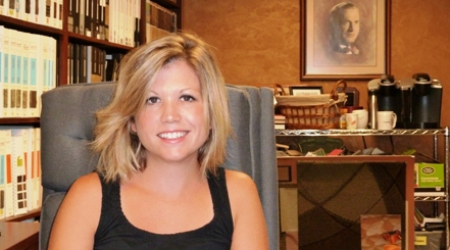 Karen Swarthout Ohri in front of a photo of her grandfather, Herbert Swarthout
