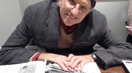 Peter Simon with his book opened to Bob Dylan photo