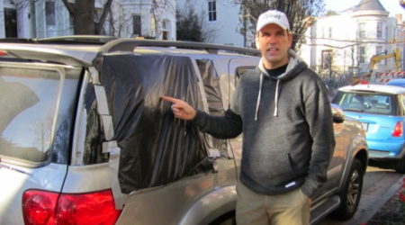 John Bradshaw point to the brick-damaged side window on his car