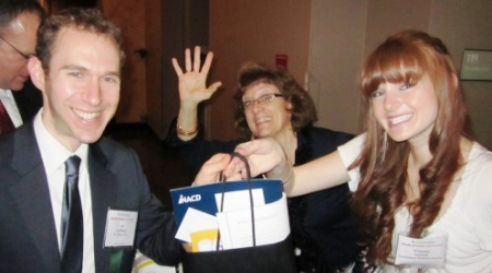 Linda Al-Jaradat (center) of the Journal waves as Al Goldberg (left) of W. Miller &amp; Co. is handed his bag by Whitney Suntum