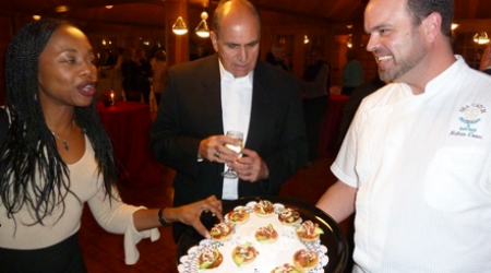 Chef Nate Coons serving Cumin Corn Blinis to Sylvie Luanghy and Zubair Popal